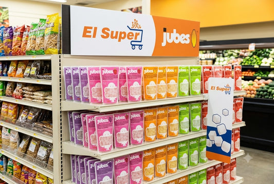 Jubes Nata De Coco shelf display in five colorful flavors under an El Super branded sign in a grocery store aisle.