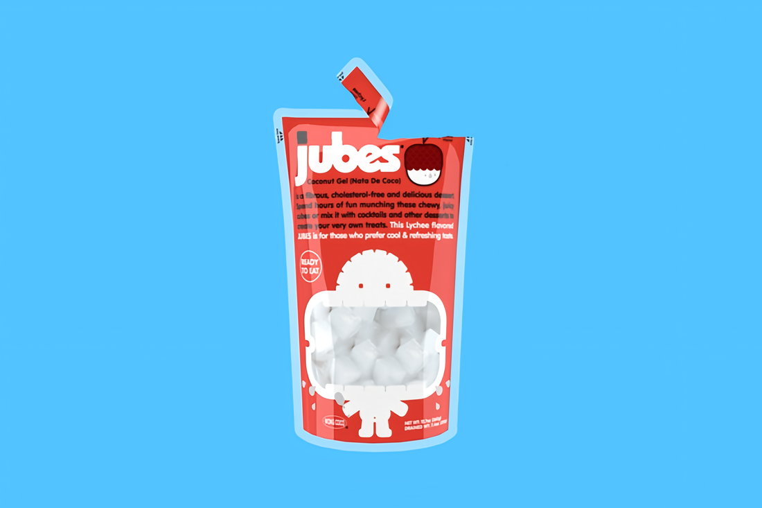 Red pouch of Jubes Lychee nata de coco snack with chewy coconut gel cubes on a blue background.