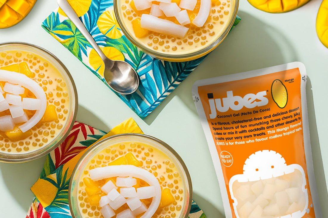 Four bowls of Mango Sago topped with nata de coco cubes, served with Jubes Mango Nata de Coco pack.