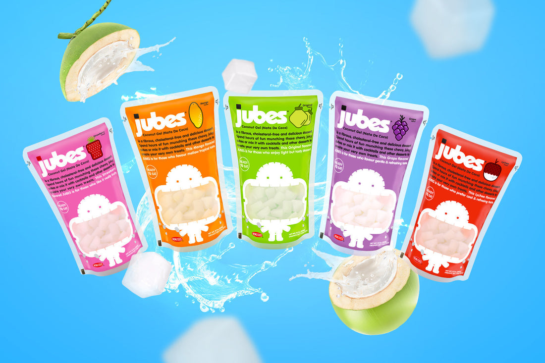 Lineup of Jubes nata de coco pouches in mango, lychee, strawberry, grape, and original flavors, each with colorful packaging.