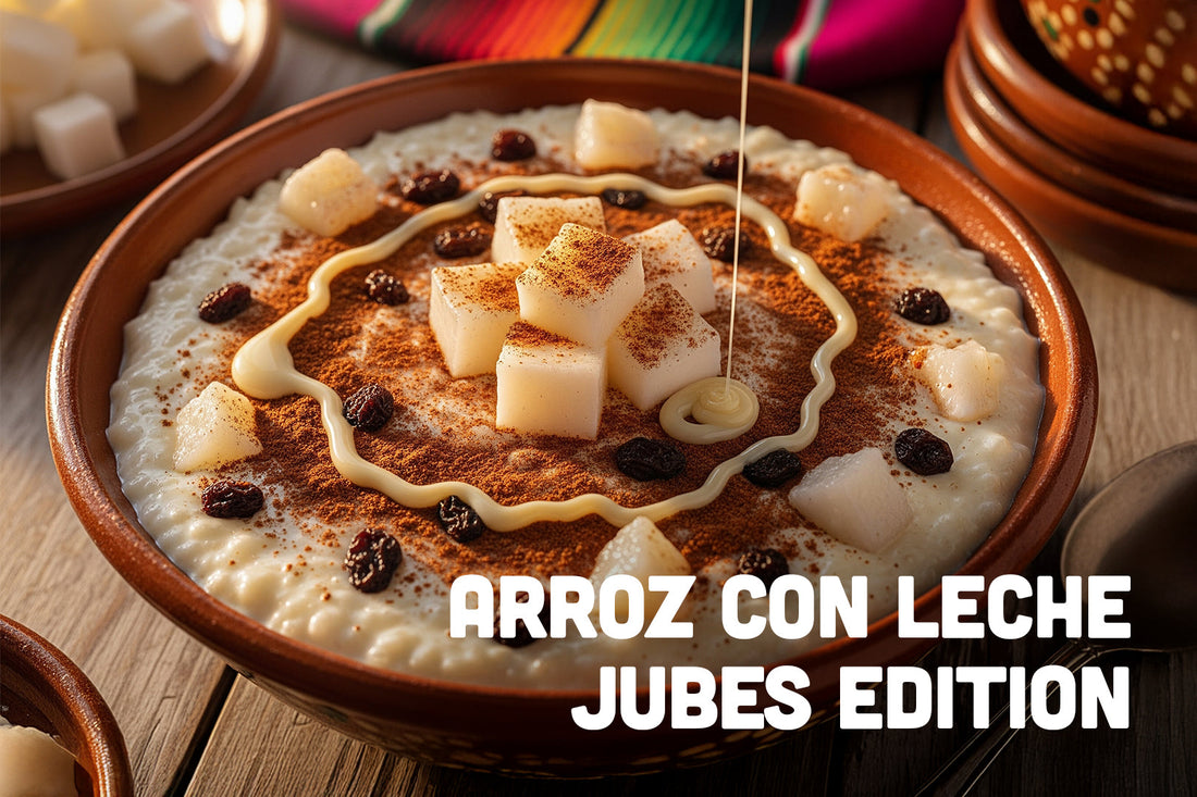 Clay bowl of Arroz con Leche topped with cinnamon, raisins, and coconut jelly cubes, with a drizzle of condensed milk, and text that reads 'Arroz con Leche Jubes Edition'.