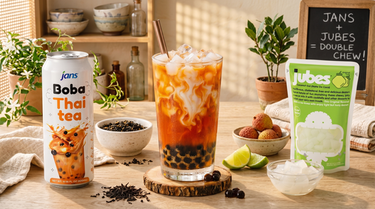 Creamy Thai iced tea with boba and Jubes nata de coco jelly cubes served over ice in a tall glass for a refreshing tropical home café drink.