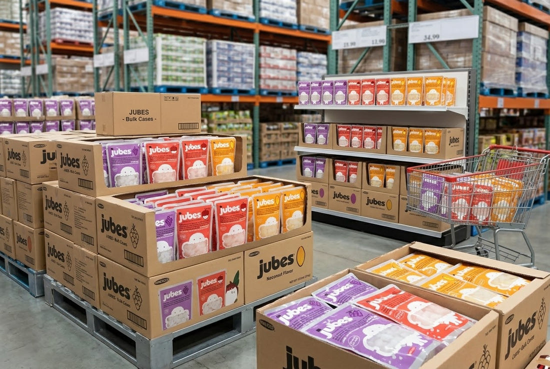Pallets of Jubes bulk cases stacked in a retail warehouse, with purple, red, and orange coconut jelly pouches stocked on shelves nearby.